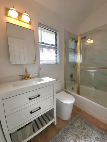 a bathroom with a double vanity sink toilet mirror and bathtub