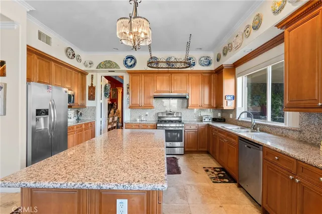 a large kitchen with stainless steel appliances granite countertop a stove refrigerator and microwave