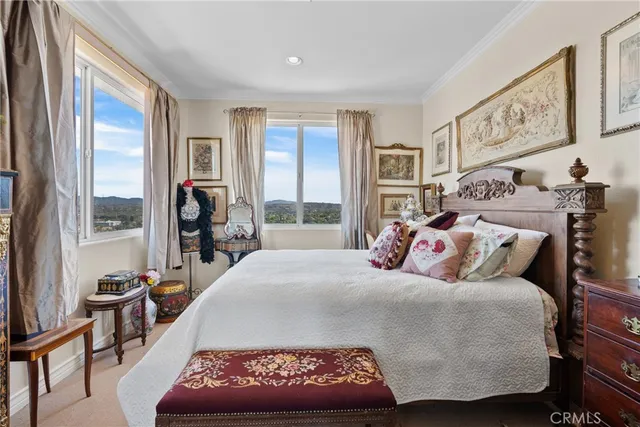 a bedroom with a bed and a large window with the outer view