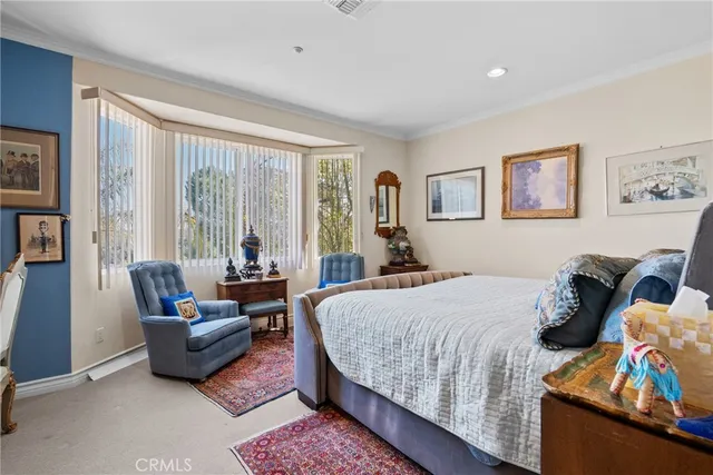 a bedroom with a bed a couch and a large window