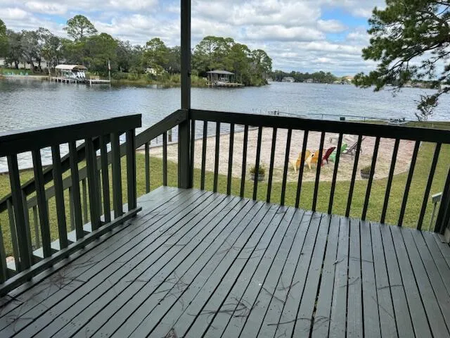 a balcony with wooden floor and lake view