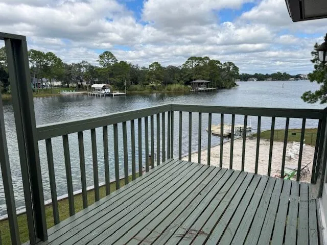 a balcony with wooden floor and lake view