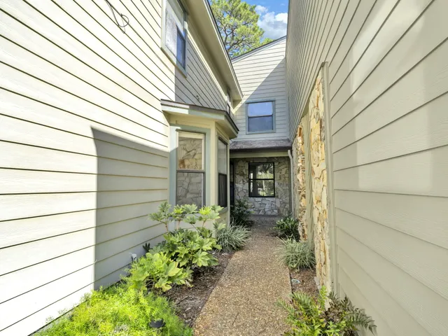 an empty room with windows and ceiling fan