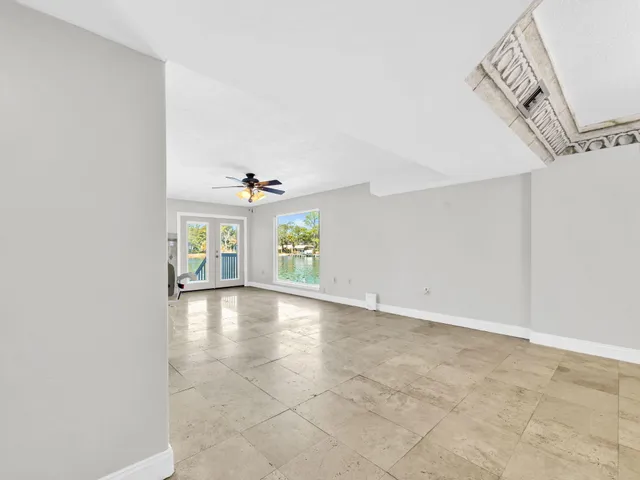 a view of an empty room with a fireplace and a chandelier