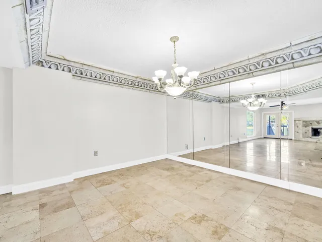 a view of an empty room with fireplace and a window