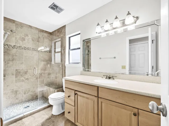 a spacious bathroom with a granite countertop sink mirror and