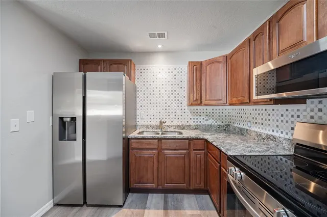 a kitchen with stainless steel appliances granite countertop a sink stove and refrigerator