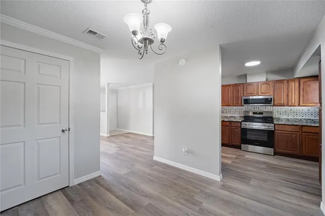 a large kitchen with hardwood floor a sink stainless steel appliances and cabinets