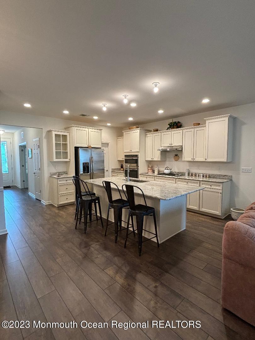 12 Harvest Ridge Road Howell, NJ 07731 - Photo 11 of 27 a living room with stainless steel appliances kitchen island granite countertop a table chairs sink and cabinets