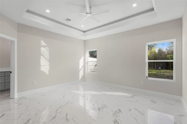 en empty room with windows and ceiling fan