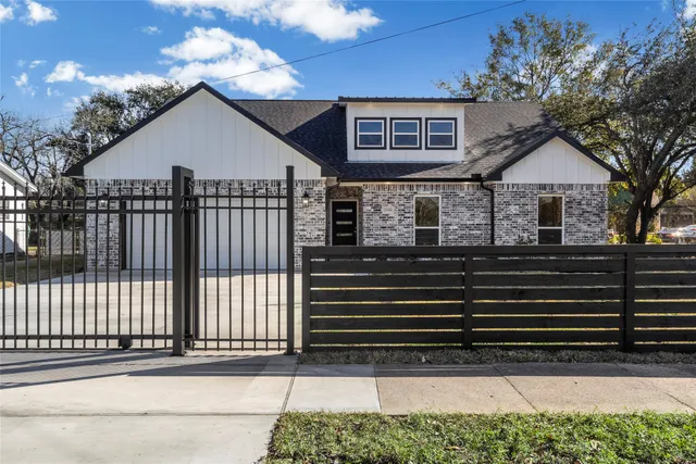 a view of a house with a small yard and wooden floor and fence
