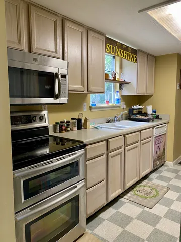 a kitchen with granite countertop cabinets stainless steel appliances and a sink