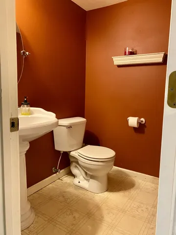 a bathroom with a toilet a sink and mirror