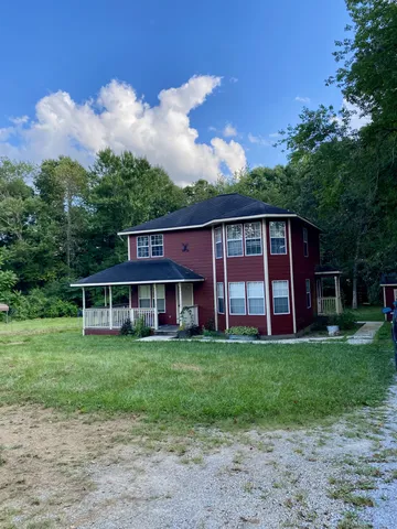 a view of a house with a yard and sitting area