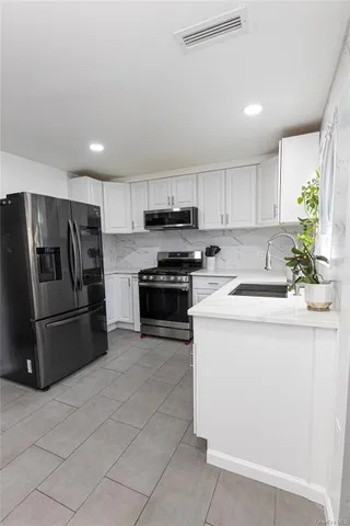 a kitchen with stainless steel appliances granite countertop a refrigerator sink and stove