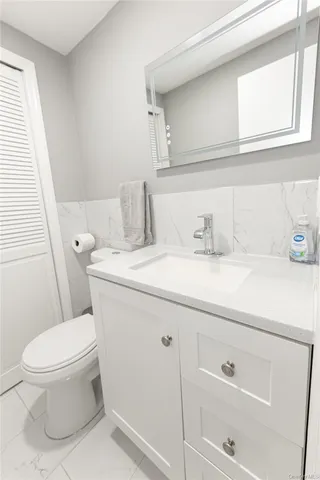 a bathroom with a toilet sink and mirror
