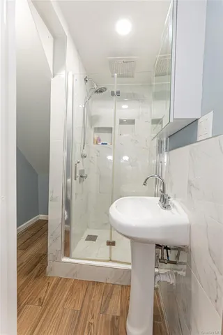 a bathroom with a sink shower and a mirror