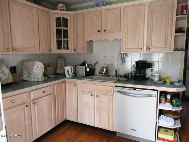 208 Rodeo Drive Hawley, PA 18428 - Photo 3 of 15 a kitchen with white cabinets and white appliances