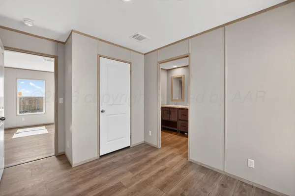 an empty room with wooden floor and cabinet