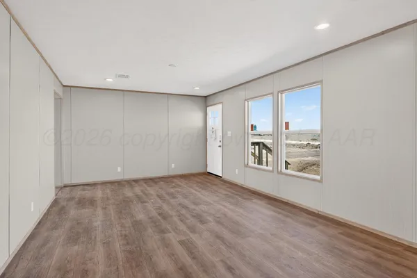 a view of a hallway with wooden floor and a cabinet