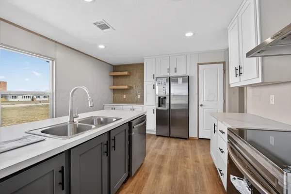 a kitchen with stainless steel appliances granite countertop a sink stove and refrigerator