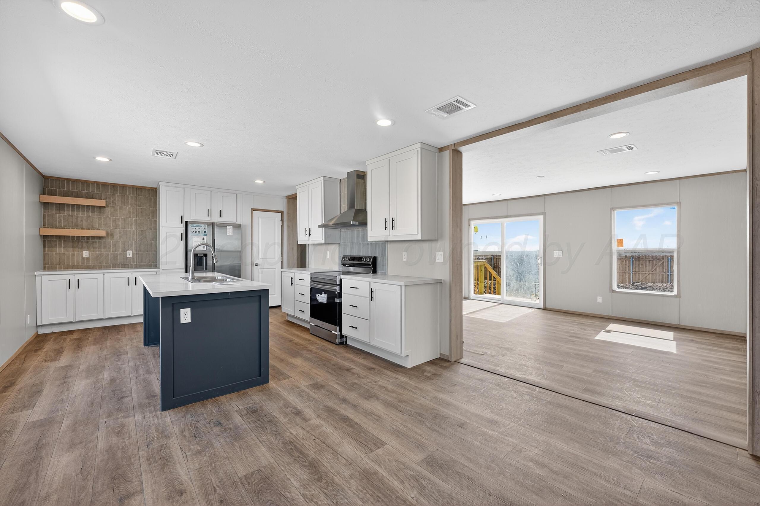2680 Avery Rd Canyon Canyon, TX 79015 - Photo 9 of 35 a large kitchen with wooden floors and white stainless steel appliances