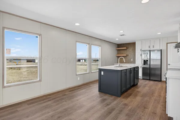 a large kitchen with a large counter top stainless steel appliances and window
