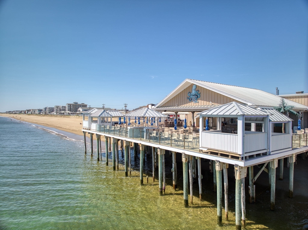 2 Sandpiper Way, Unit A Salisbury, MA 01952 - Photo 28 of 30 a roof deck with table and chairs under an umbrella next to an ocean