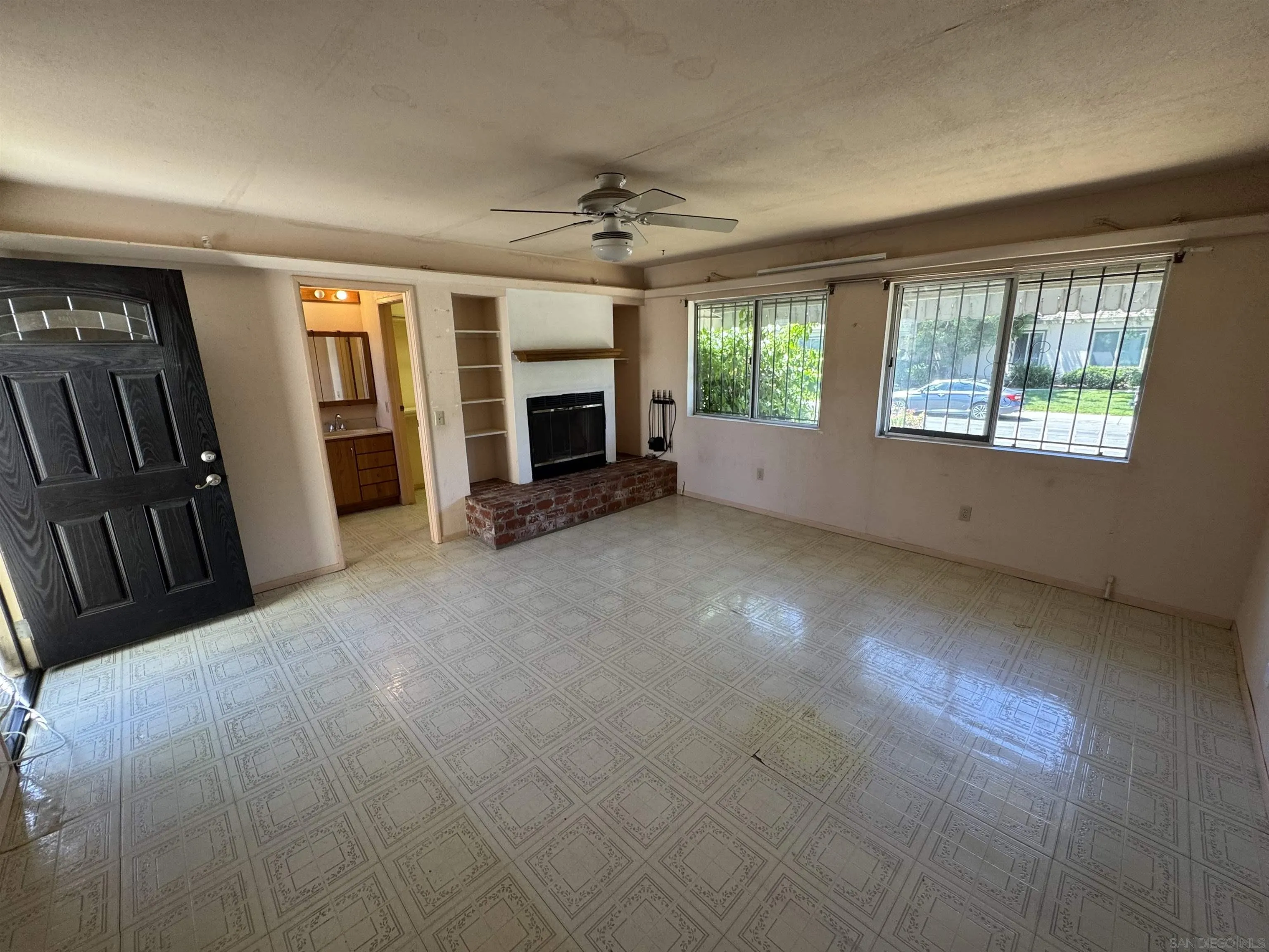10490 Stanfield Circle San Diego, CA 92126 - Photo 8 of 21 an empty room with windows fireplace and a kitchen view