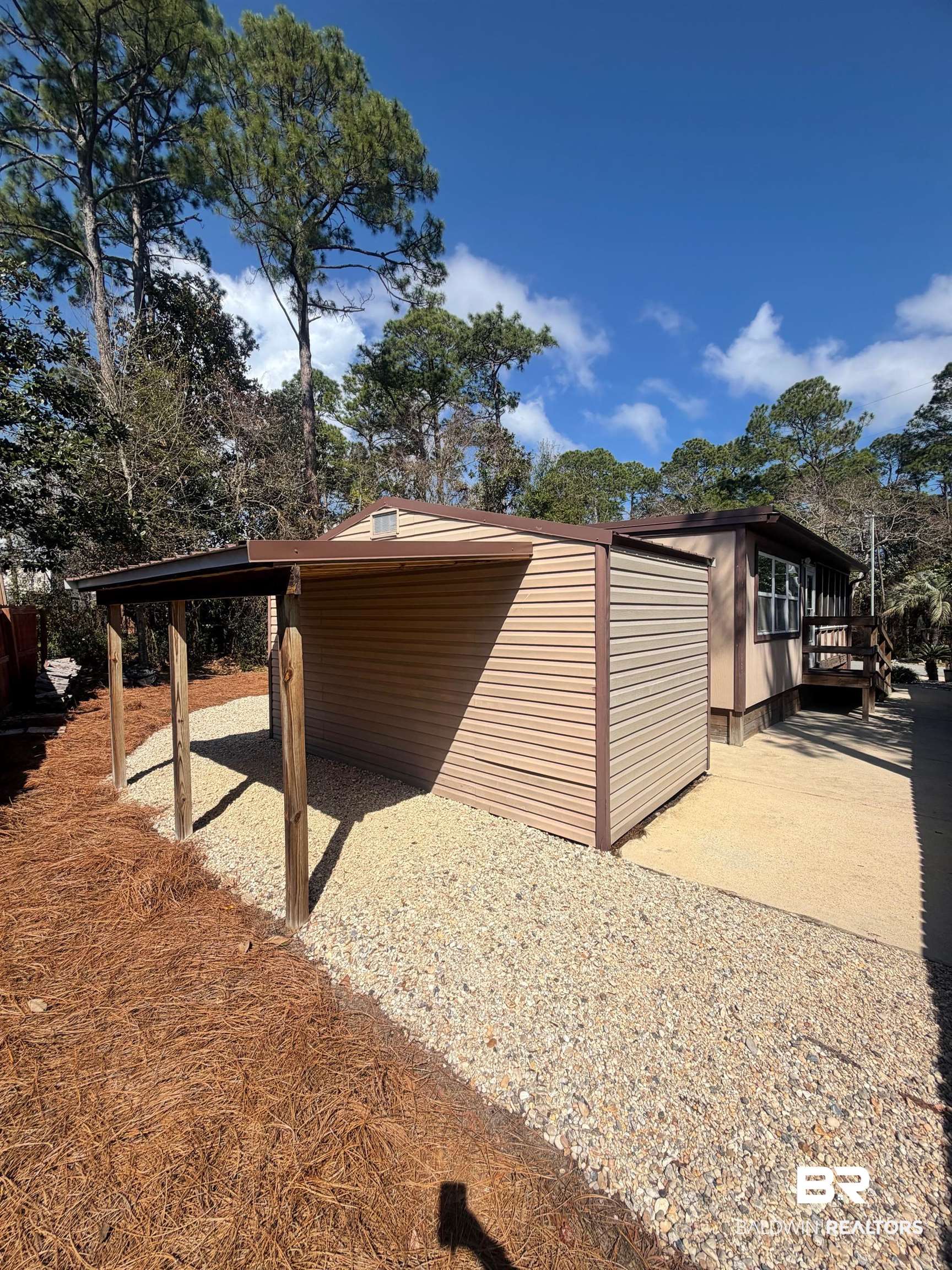 685 Escambia Loop Lillian, AL 36549 - Photo 20 of 43 View of side of property with a carport and a wooden deck