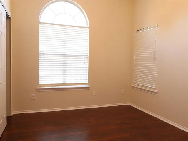 an empty room with wooden floor and a window
