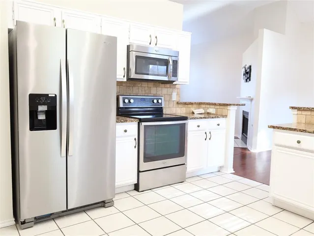 a kitchen with stainless steel appliances a refrigerator stove and microwave
