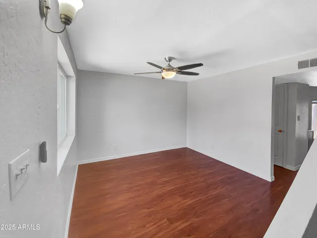 a view of an empty room with a chandelier fan