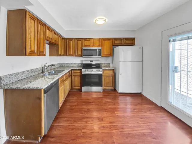 a kitchen with stainless steel appliances granite countertop a sink stove and refrigerator