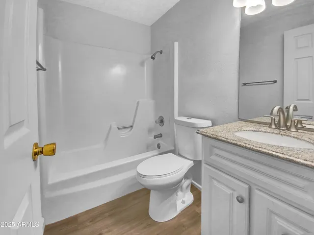 a bathroom with a granite countertop toilet a sink and a bathtub