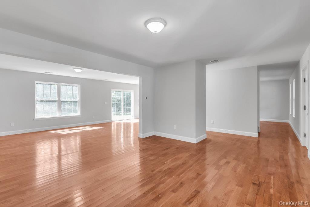 113 Currans Road Middle Island, NY 11953 - Photo 12 of 32 an empty room with wooden floor and windows