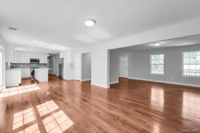 a view of a living room and kitchen with furniture and wooden floor
