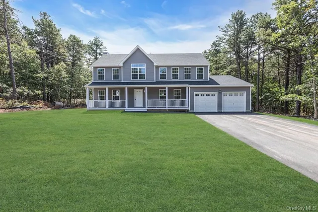 a view of a house next to a big yard and large trees