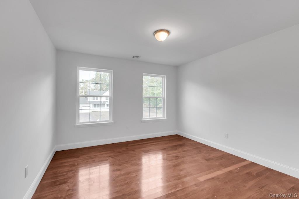 113 Currans Road Middle Island, NY 11953 - Photo 25 of 32 an empty room with wooden floor and windows