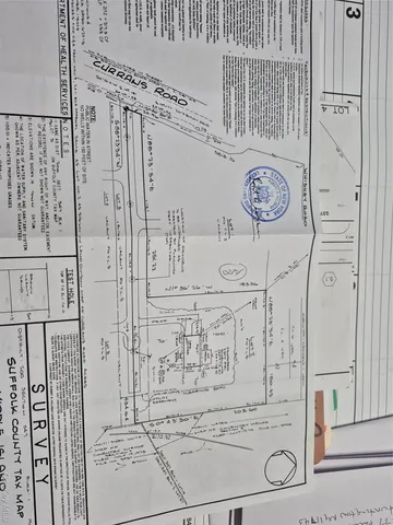 a view of a white house with a big yard with large trees