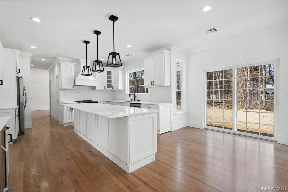 113 Currans Road Middle Island, NY 11953 - Photo 4 of 32 a large kitchen with kitchen island a large counter top space a sink stainless steel appliances and cabinets