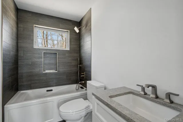 a bathroom with a granite countertop toilet a sink and bathtub