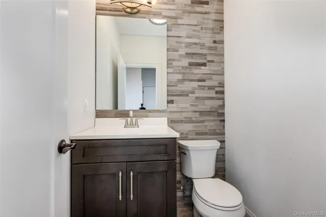 a bathroom with a toilet a sink and mirror