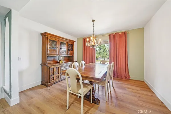 a dining room with furniture a chandelier and wooden floor