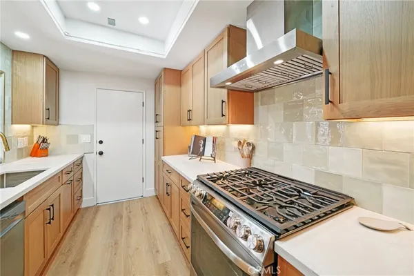 a kitchen with stainless steel appliances granite countertop a sink stove and cabinets