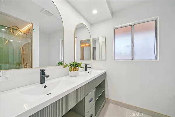a bathroom with a tub a sink and mirrors