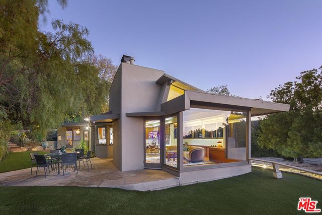 a view of a house with a yard patio and a garden