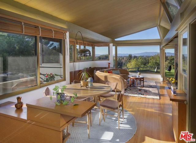 a dining room with furniture water view and large windows