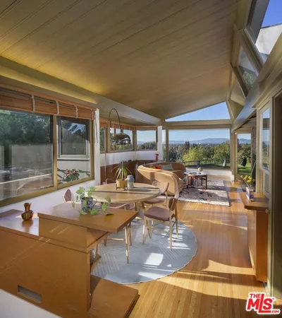 a view of a patio with table and chairs potted plants and large tree