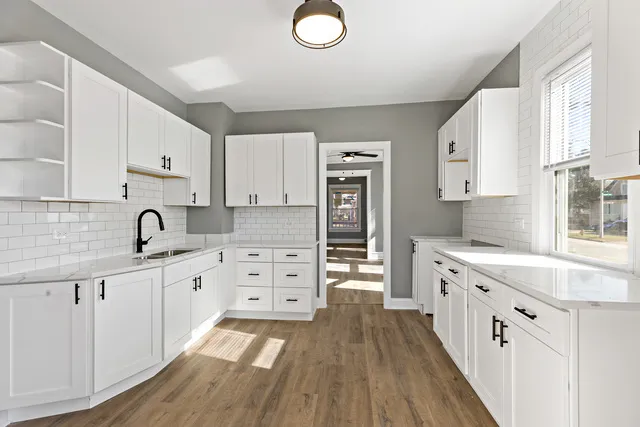 a kitchen with white cabinets and appliances